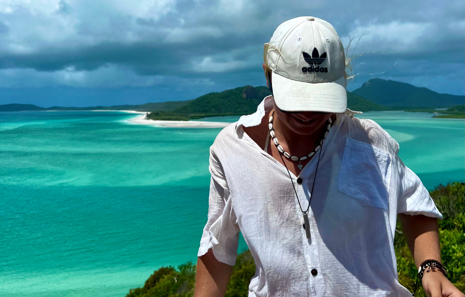 Mädchen mit weißer Kappe mit türkisenem Meer im Hintergrund