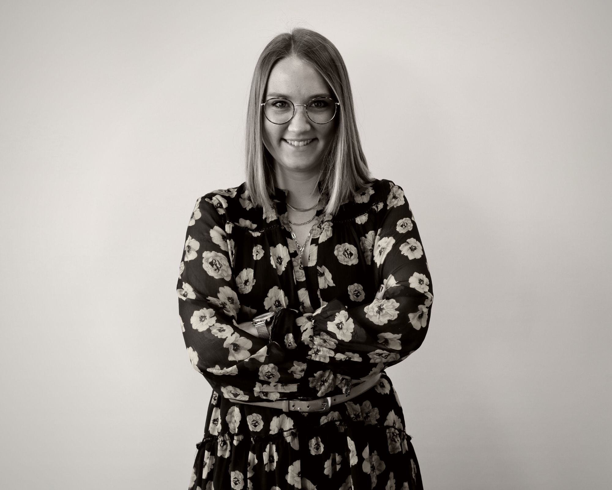 Schwarz-weiß Bild einer in die Kamera lächelnden jungen Frau