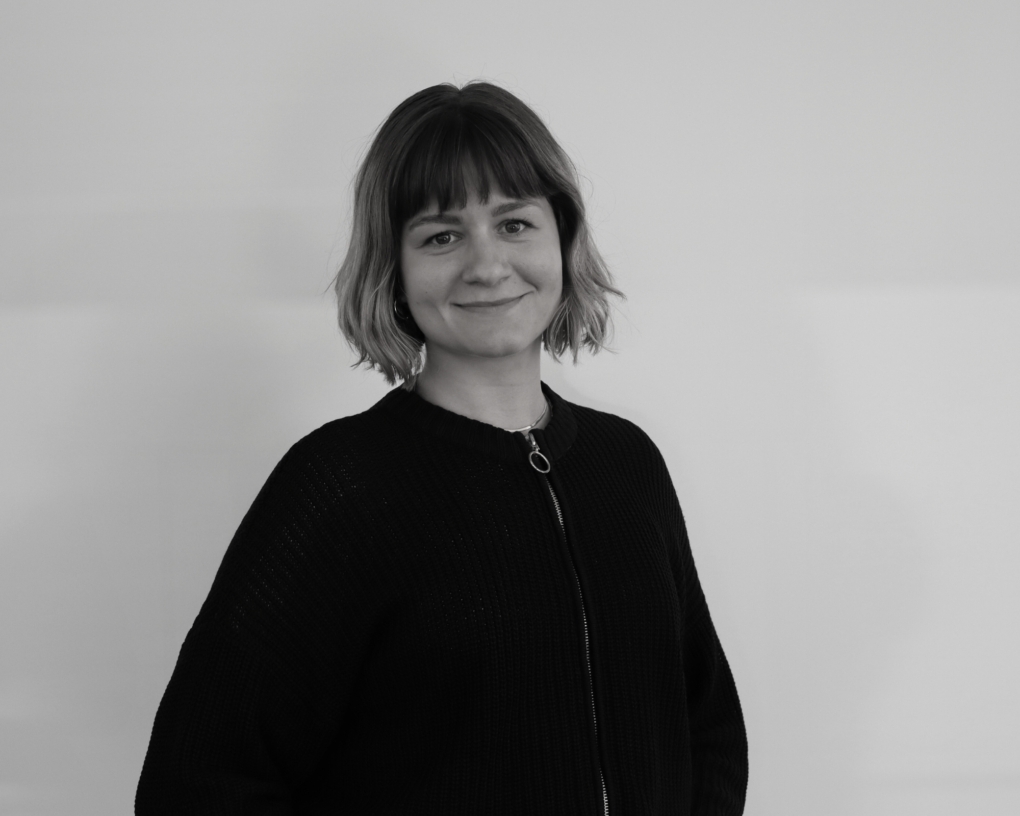 Schwarz weiß Bild einer jungen Frau, die in die Kamera lächelt